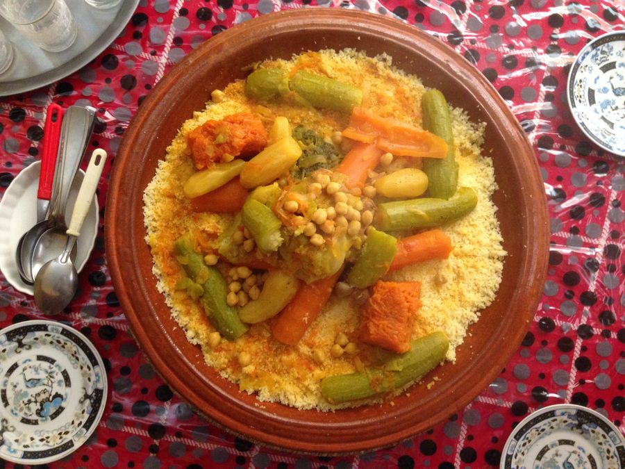 Couscous topped with vegetables and chickpeas on a shared plate